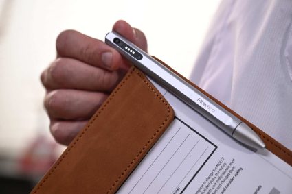 male hand holding clipboard silver pen clipped white shirt