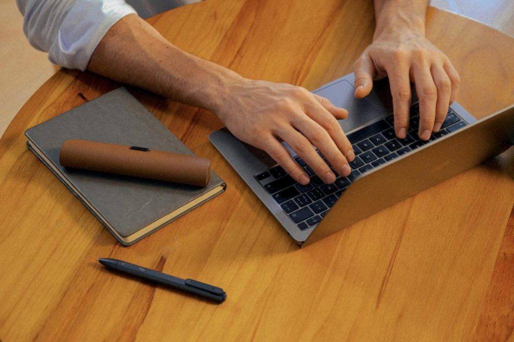 product hands typing macbook pen case round table product hands typing macbook pen case round table